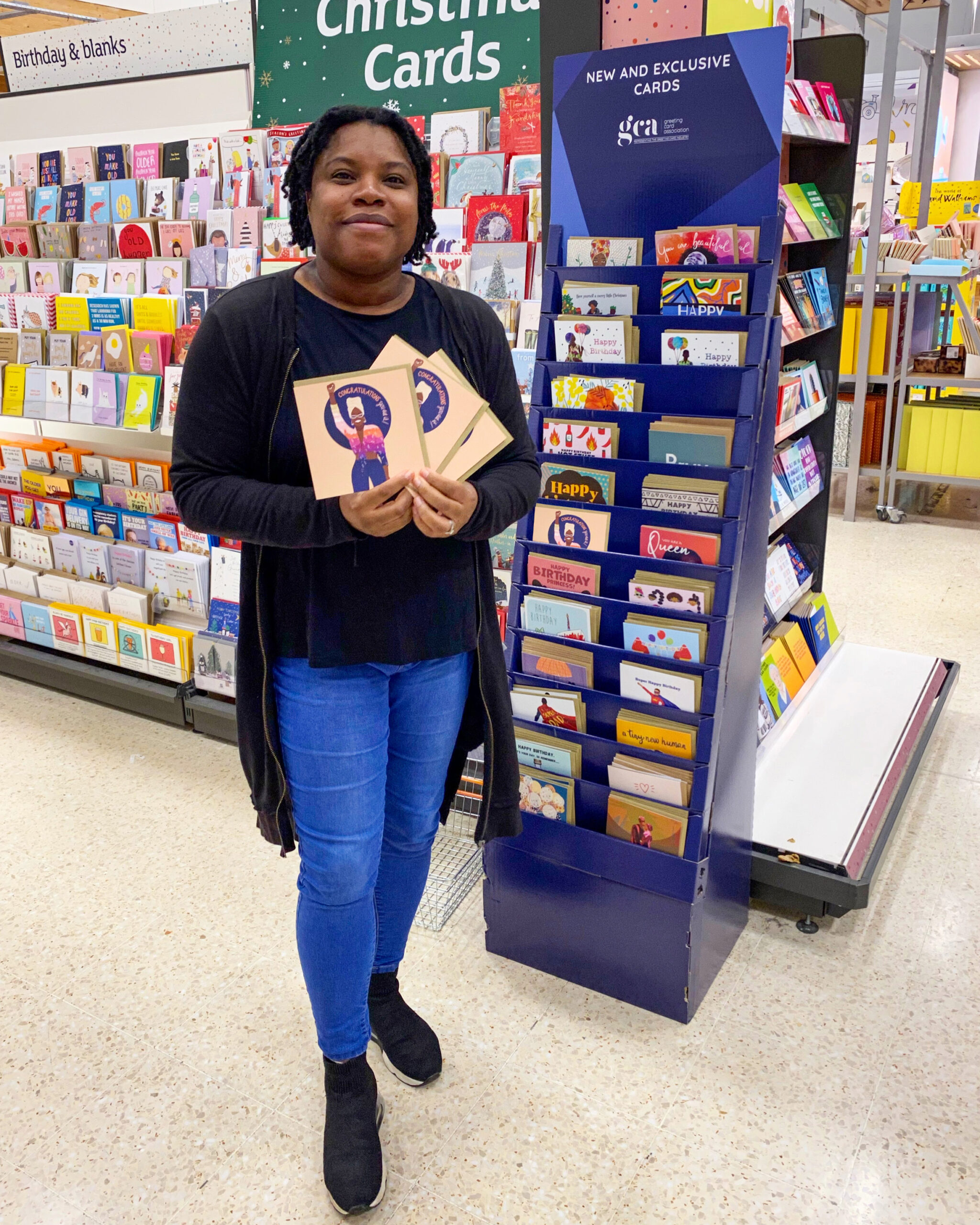 Kareen Cox standing with her Black History Months cards in Sainsburys